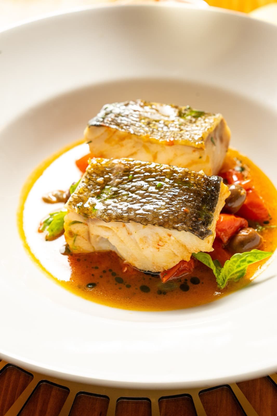 Filetti di pescato con pomodorini, olive e basilico in guazzetto